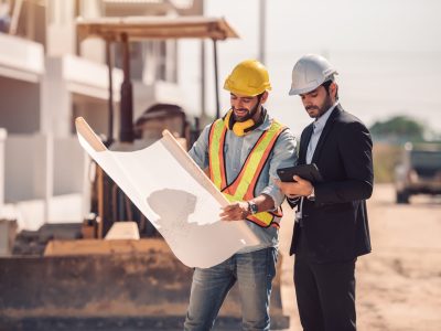Civil engineer and construction worker manager holding digital tablet and blueprints , talking and planing about construction site.  Cooperation teamwork concept.