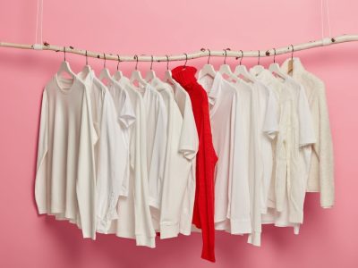 ladies-white-casual-clothes-arranged-hangers-red-knitted-warm-sweater-stands-out-whole-collection-dressing-set-hanging-against-pink-background-home-wardrobe-classic-style-fashion-shop_273609-32738